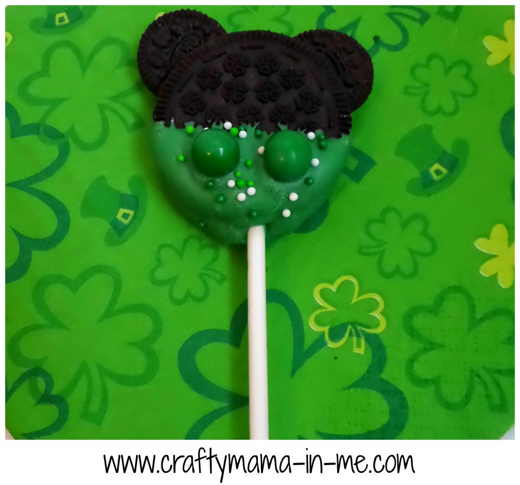 Luck O The Irish Disney Oreo Pops made from big Oreos, small Oreos, dipped in green chocolate, with white and green sprinkles, and 2 green sixlets.